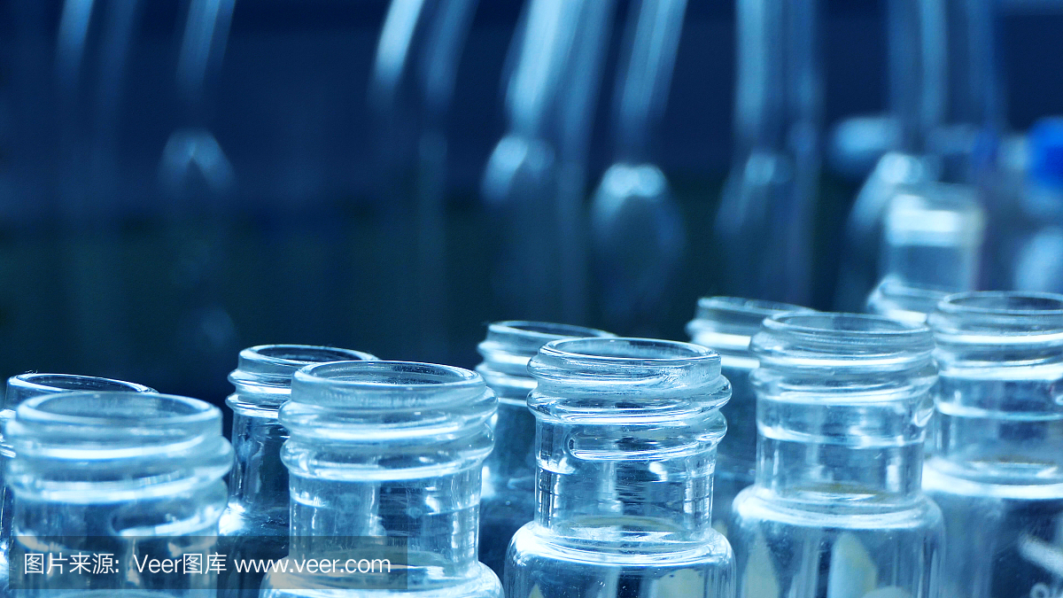 具有实验室背景、科学或医学研究和发展理念的科学家,使用滴管取样油或化学液体滴到装有实验室玻璃器皿的试管中